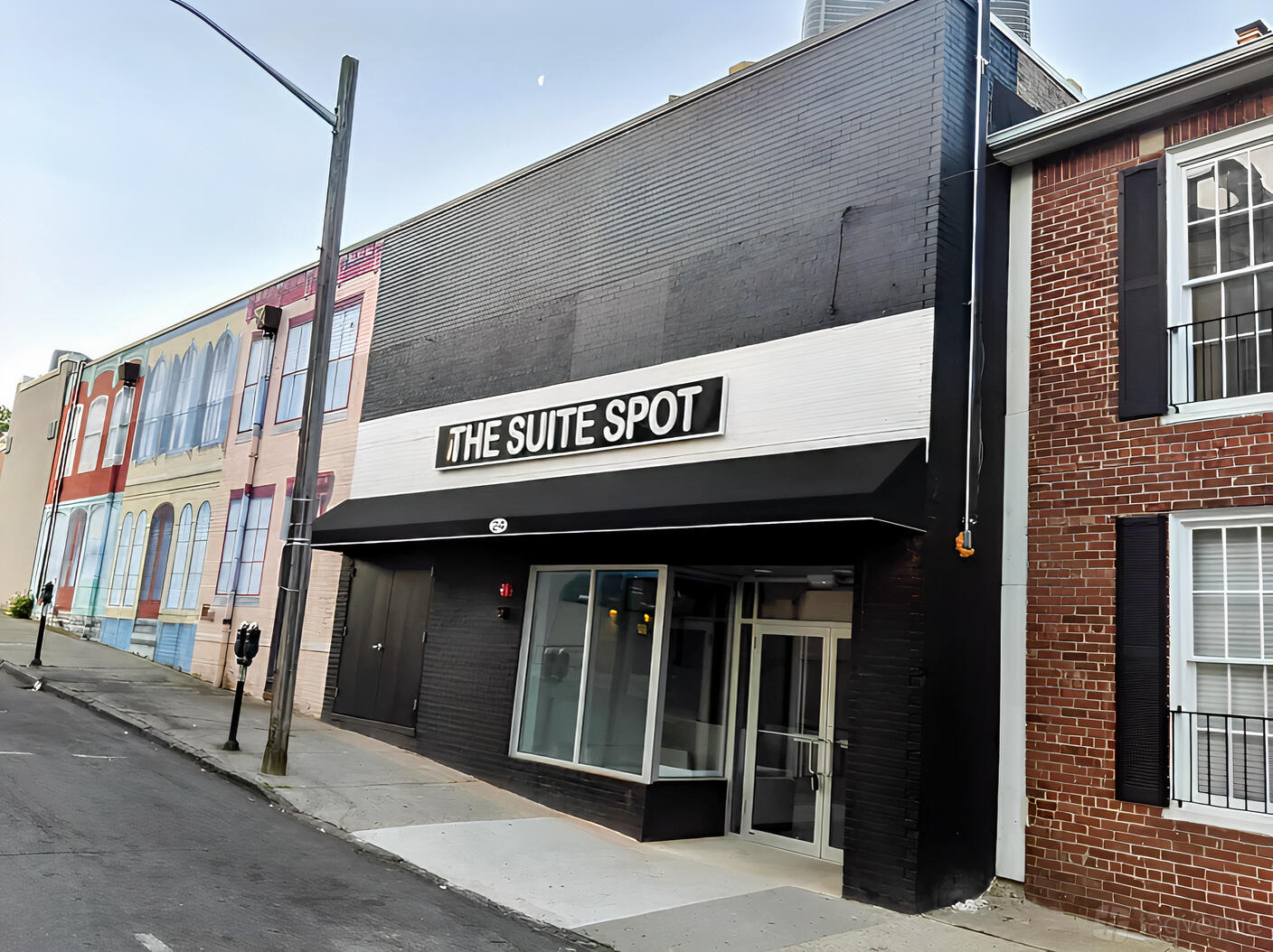 A versatile event space with a glass entrance and black awning on a city street at The Suite Spot.