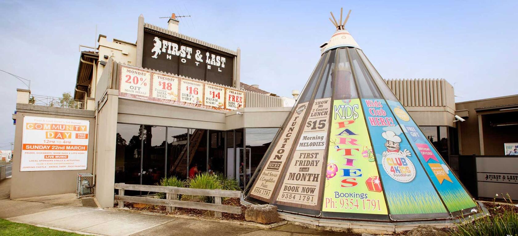 A hotel entrance with a prominent sign and a tipi-shaped kids’ party area at First & Last Hotel.