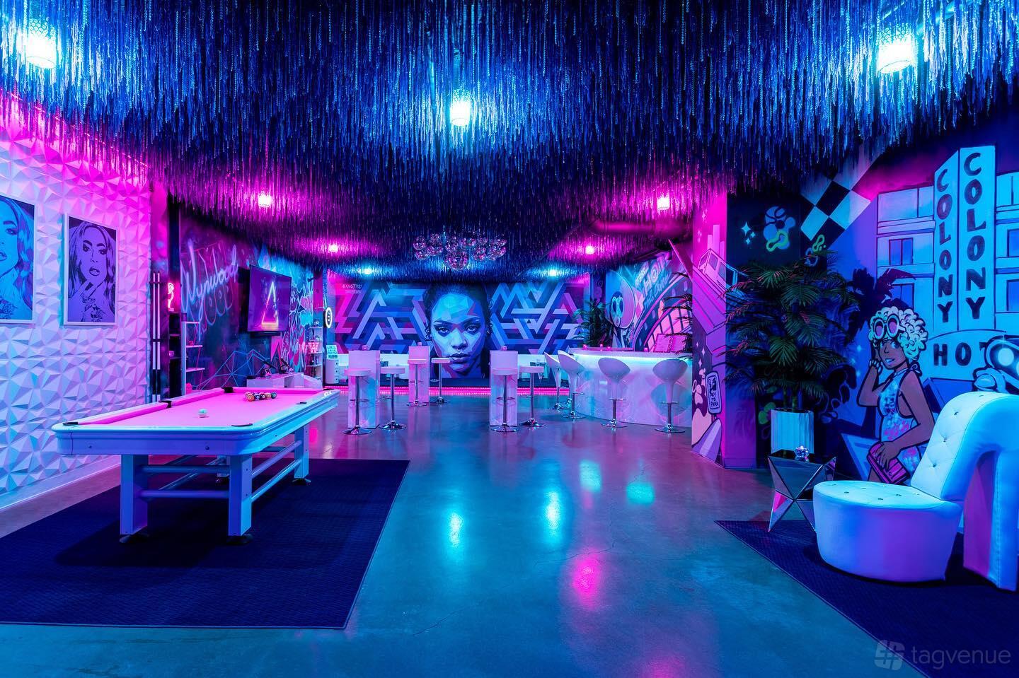 An event venue with neon lighting, pop art murals, and a pool table at Social Cues - Wynwood.