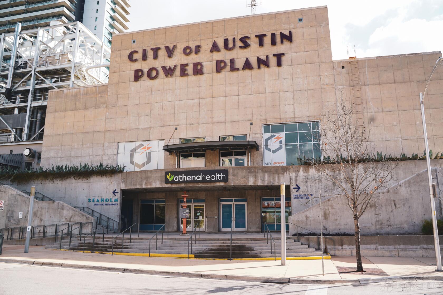 A versatile event space in a concrete building with large windows and industrial signage at Generator Athlete Lab.