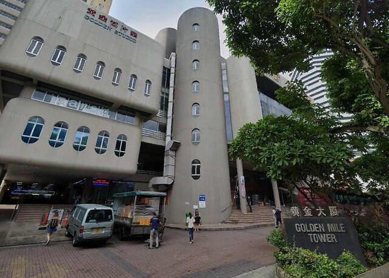 An academic building with curved concrete facade, cylindrical stairwell, and trees outside CuriousCore.