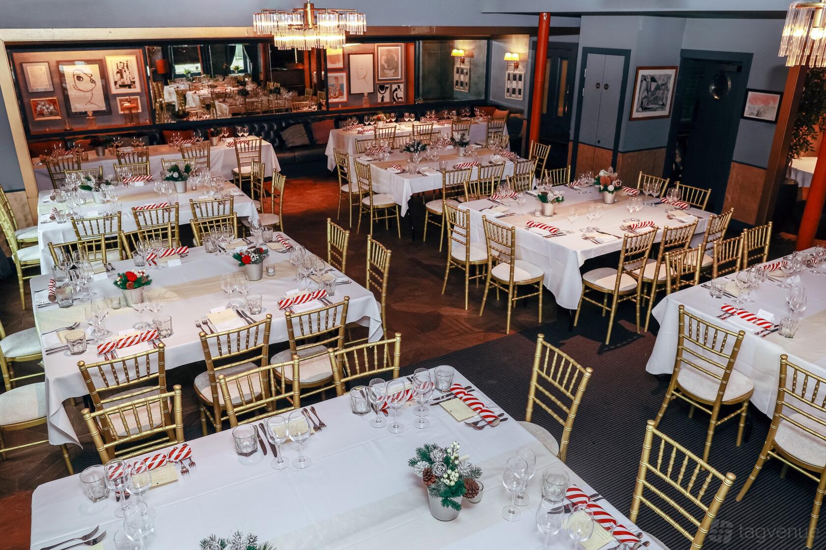 A dining room with gold Chiavari chairs, white tablecloths, and framed artwork at Albert's at Beaufort House.