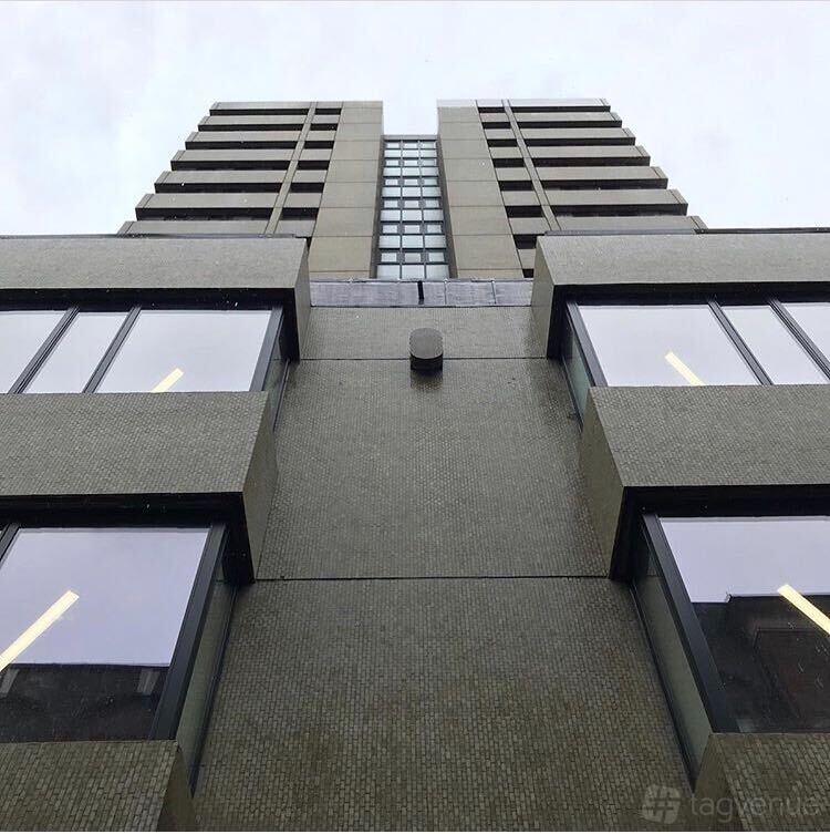 A coworking space with a modern high-rise exterior, large windows, and tiled facade at Huckletree Soho.