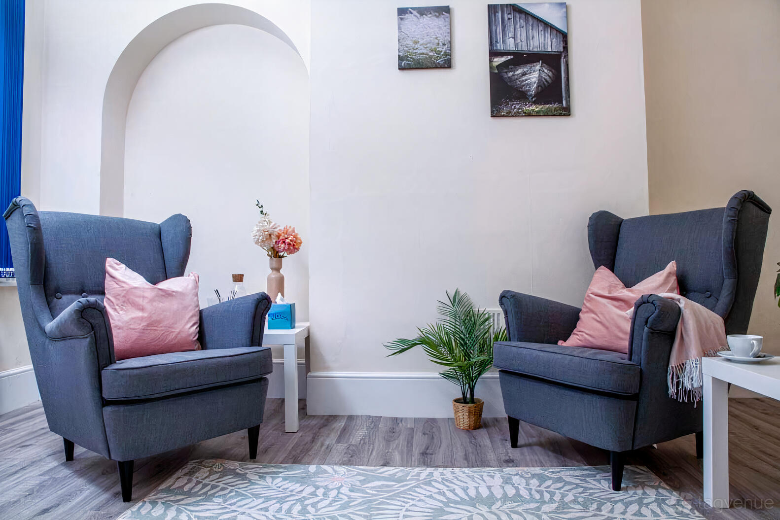 A therapy room with two upholstered armchairs, a patterned rug, and framed wall art at The British Engineerium.
