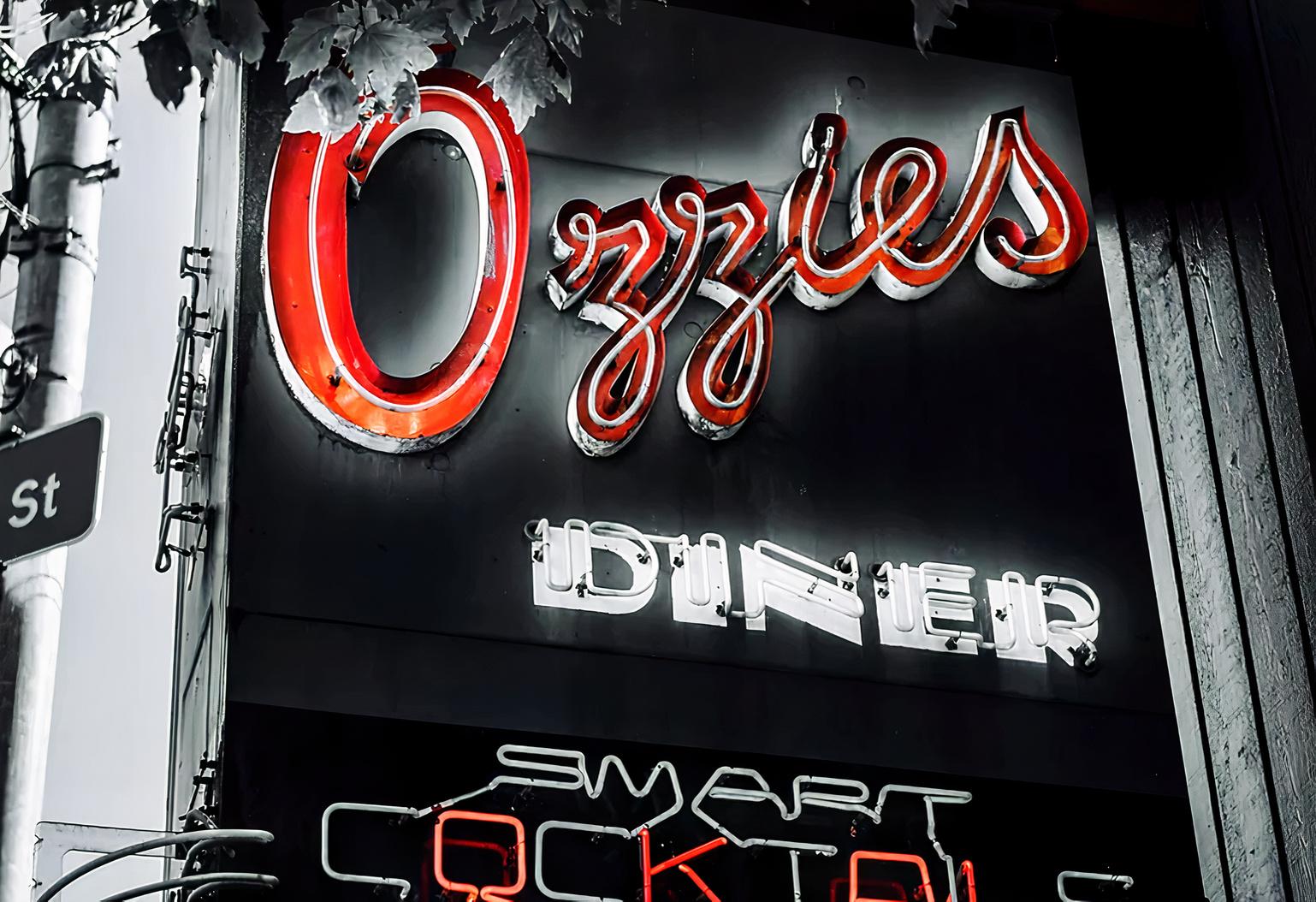 A pub and bar with a neon-lit sign reading 'Ozzie's Diner' outside Ozzie's in Seattle.