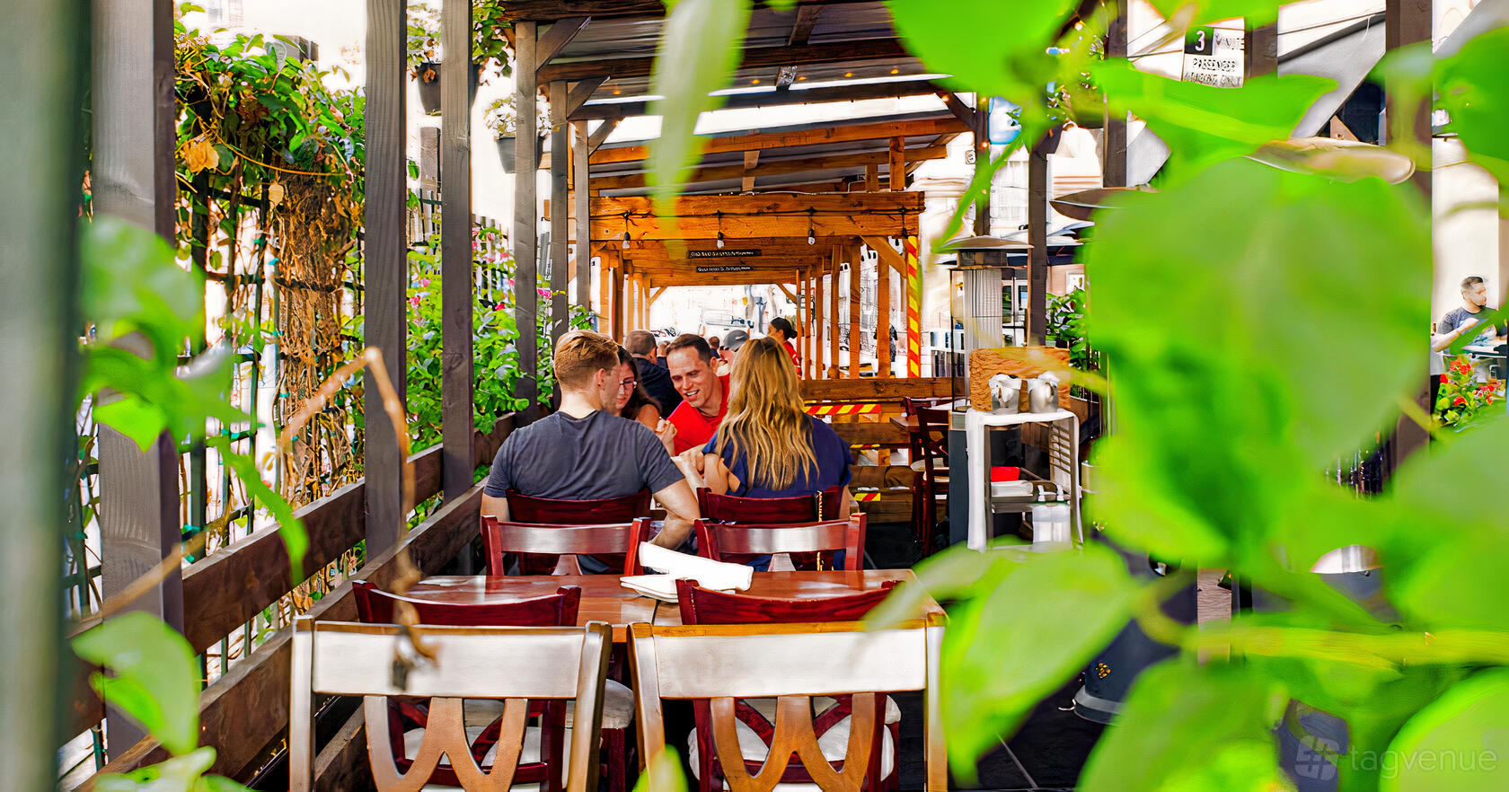 An outdoor dining patio with wooden pergolas, string lights, and greenery at il Sogno Italiano.