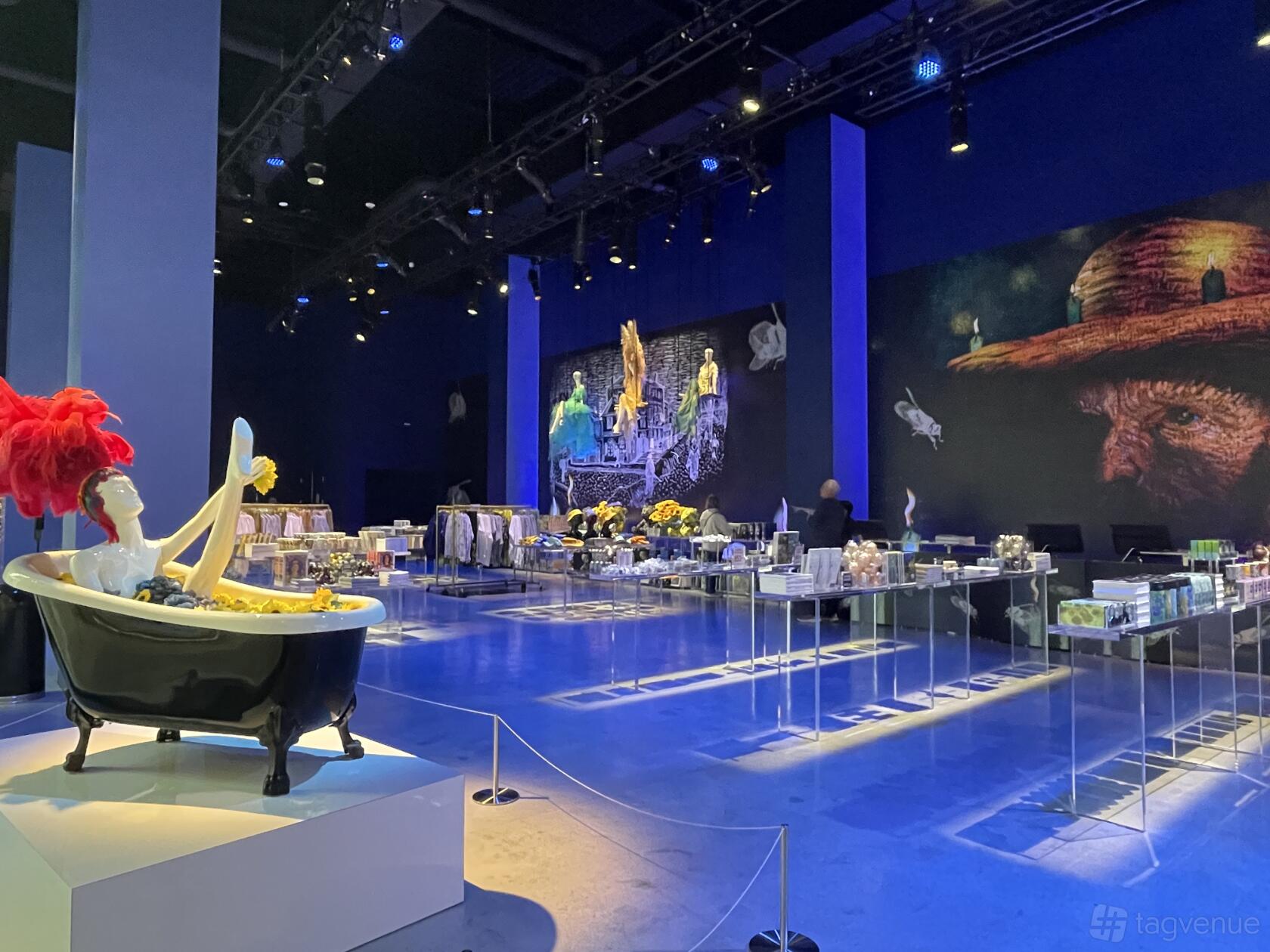 A spacious gallery with high ceilings, digital wall art projections, and retail displays at Lighthouse Artspace Las Vegas.