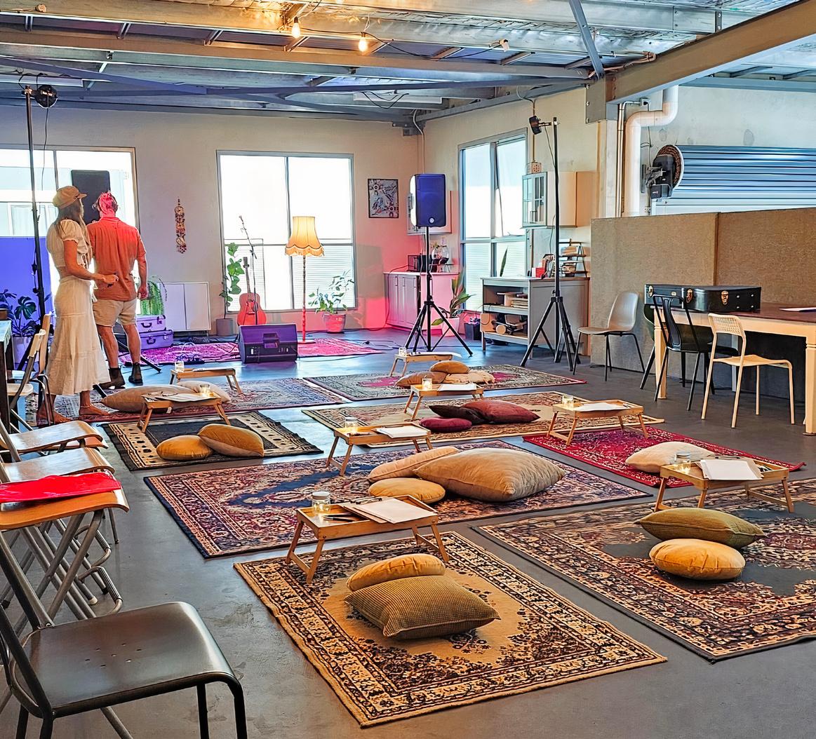 A function room with patterned rugs, floor cushions, low tables, and ambient lighting at Chris' Kitchen.