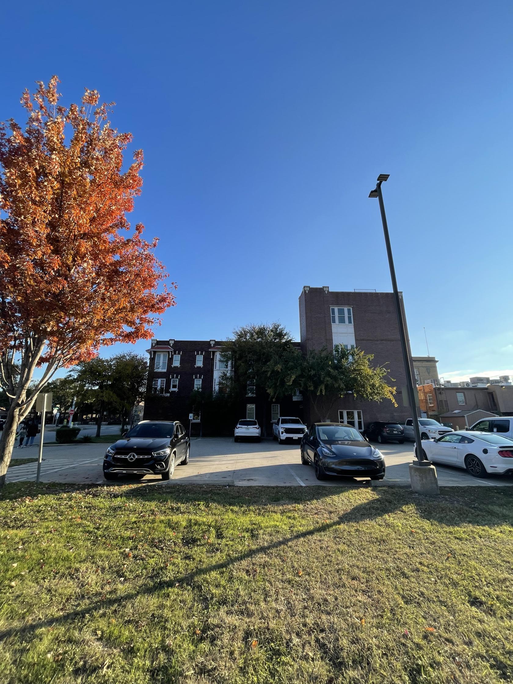 A versatile event space with a red brick exterior, several windows, and adjacent parking at IMSpaces.
