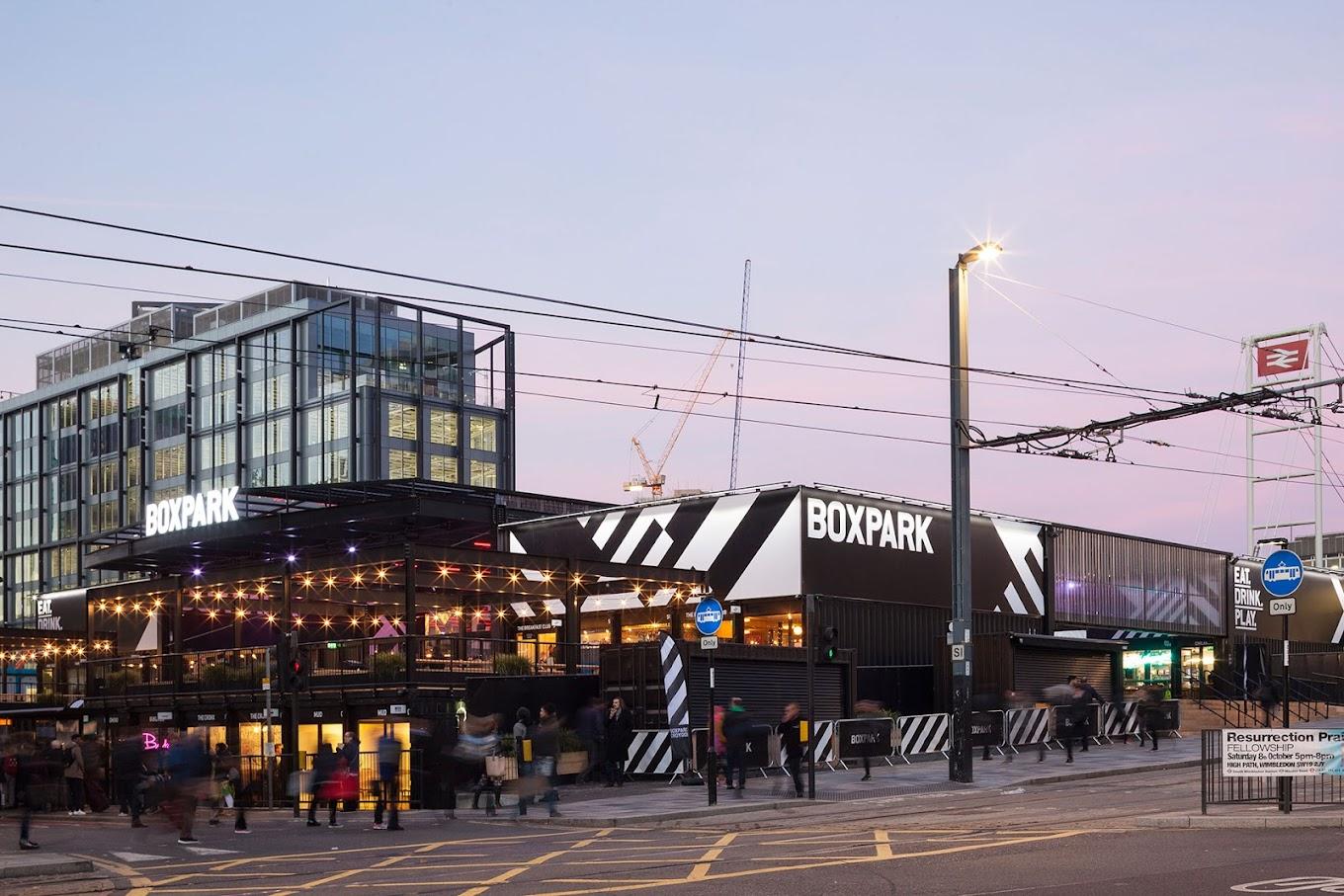 A restaurant with bold black and white exterior signage and an open-air upper deck at Boxpark Croydon.