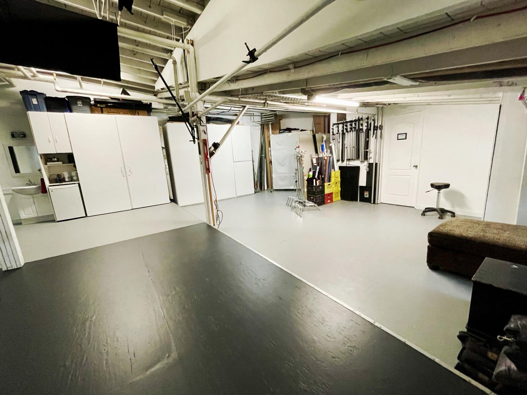 A photo studio with seamless backdrops, storage cabinets, and lighting equipment at Tonino Guzzo Studios.