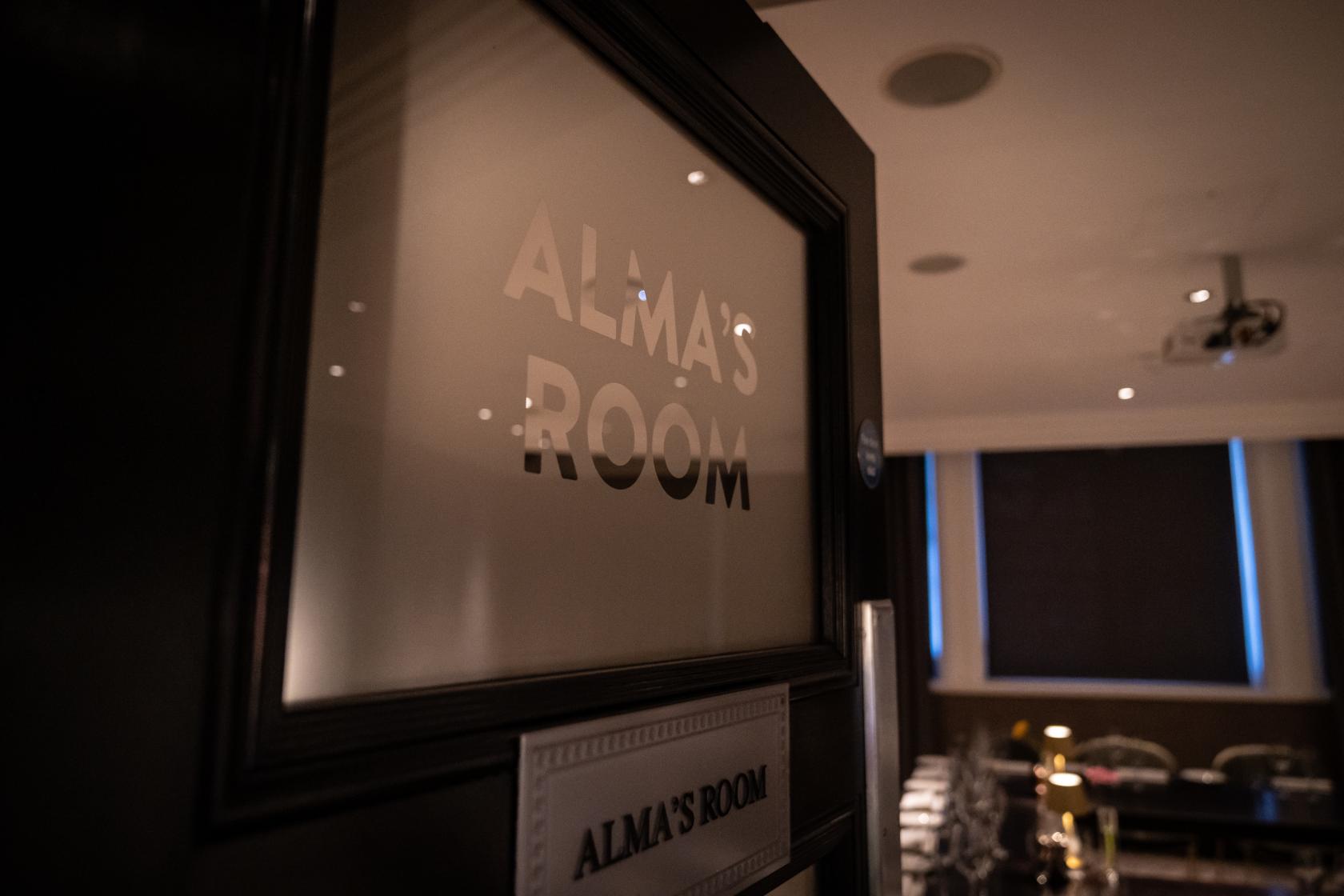 A meeting room with blackout blinds, ceiling lights, and a projector at The Hippodrome Casino.