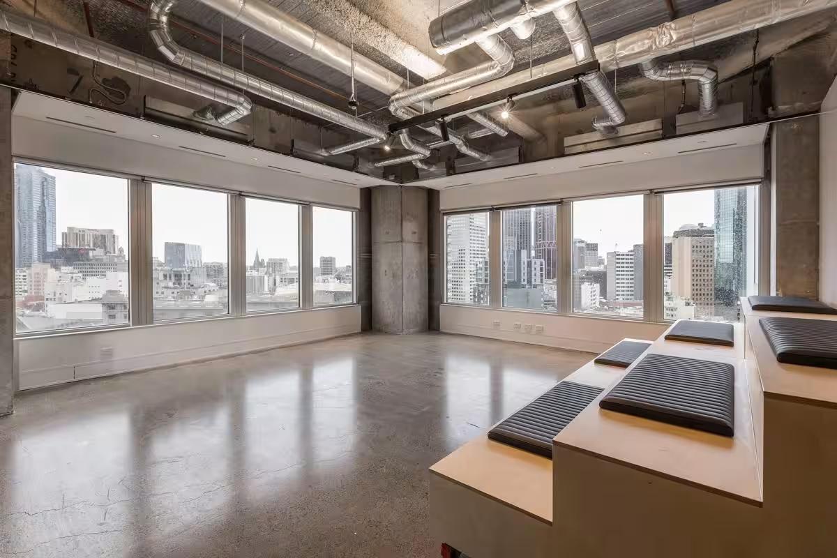 A training room with large windows, polished concrete floors, exposed ceilings, and tiered seating at Space&Co. Melbourne Central Tower.