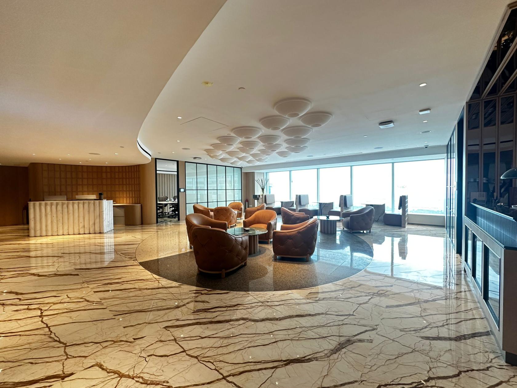 An event space with marble floors, leather lounge chairs, and floor-to-ceiling windows at Singapore Land Tower.