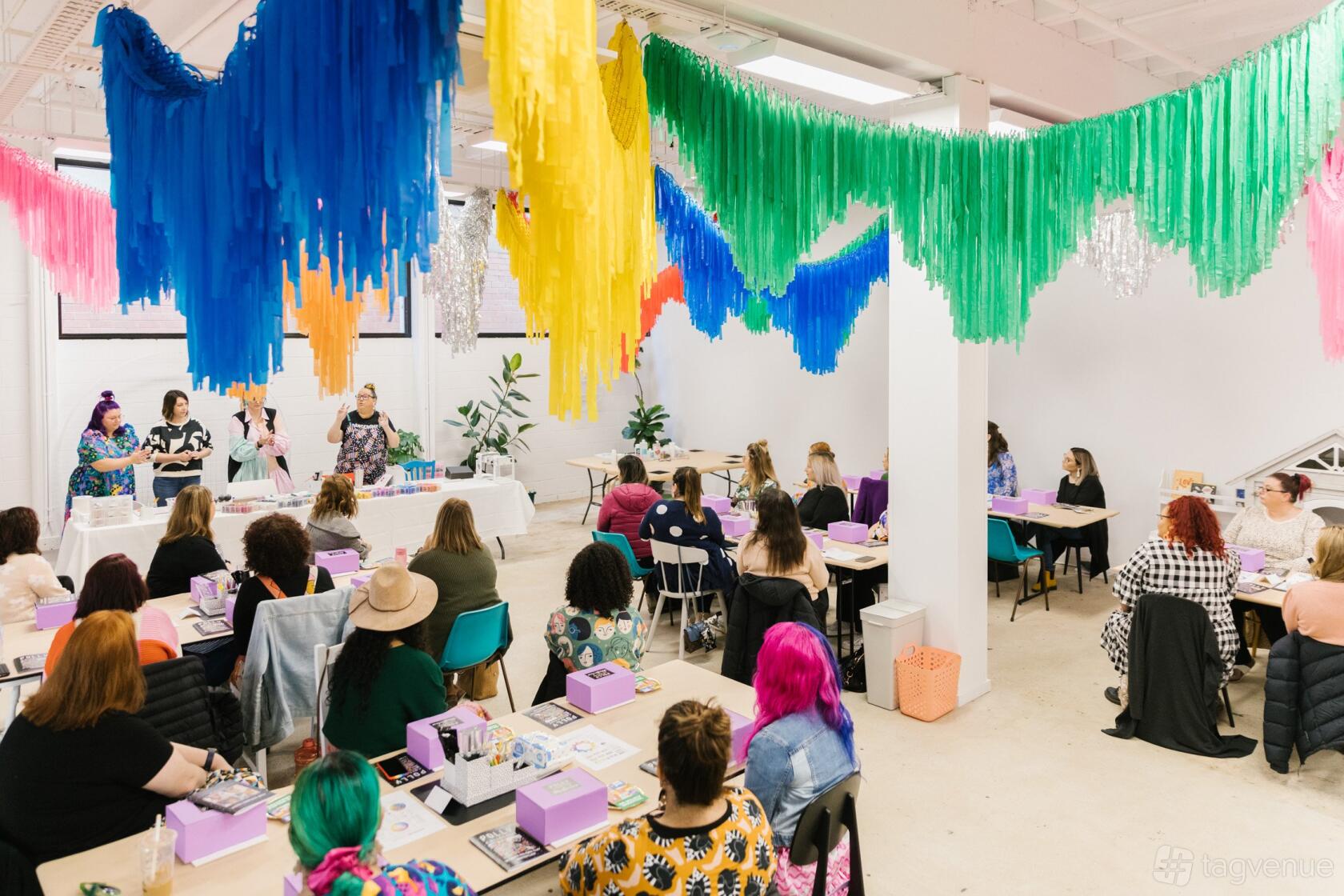 A photo studio with white walls, large windows, and colorful fringe decorations hanging from the ceiling at Studio Safari.