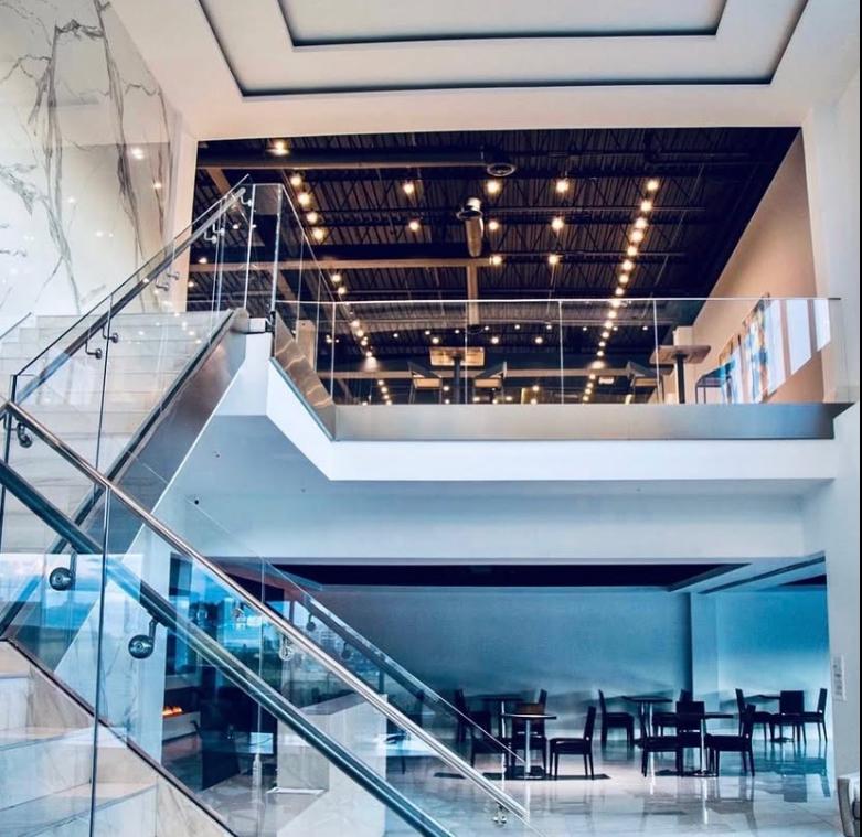 An event venue with high ceilings, glass railings, and exposed ductwork at M Club.