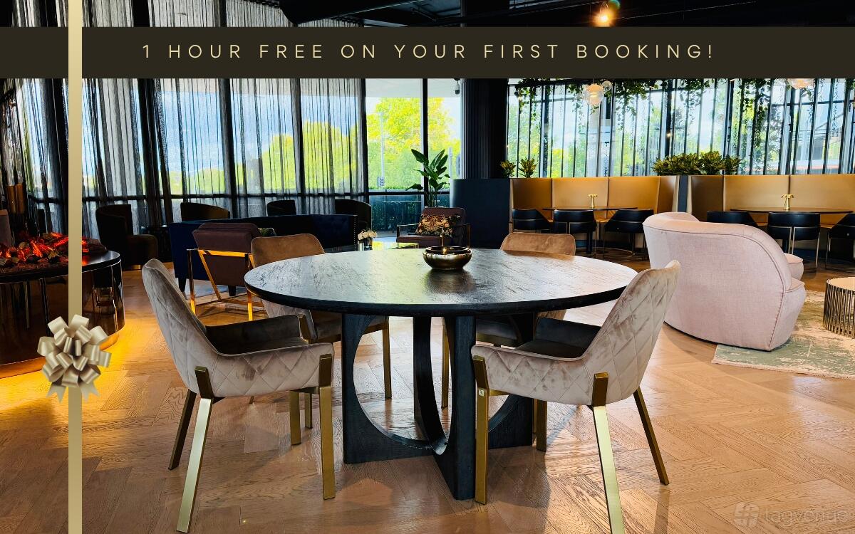 A meeting room with a round dark wood table, upholstered chairs, and floor-to-ceiling windows at LXD Lounge Chadstone.