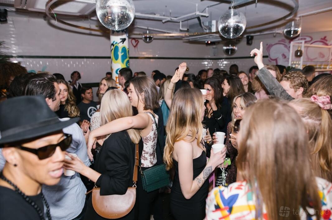 A nightclub with disco balls, patterned columns, and a lively crowd at Le Bab Covent Garden.