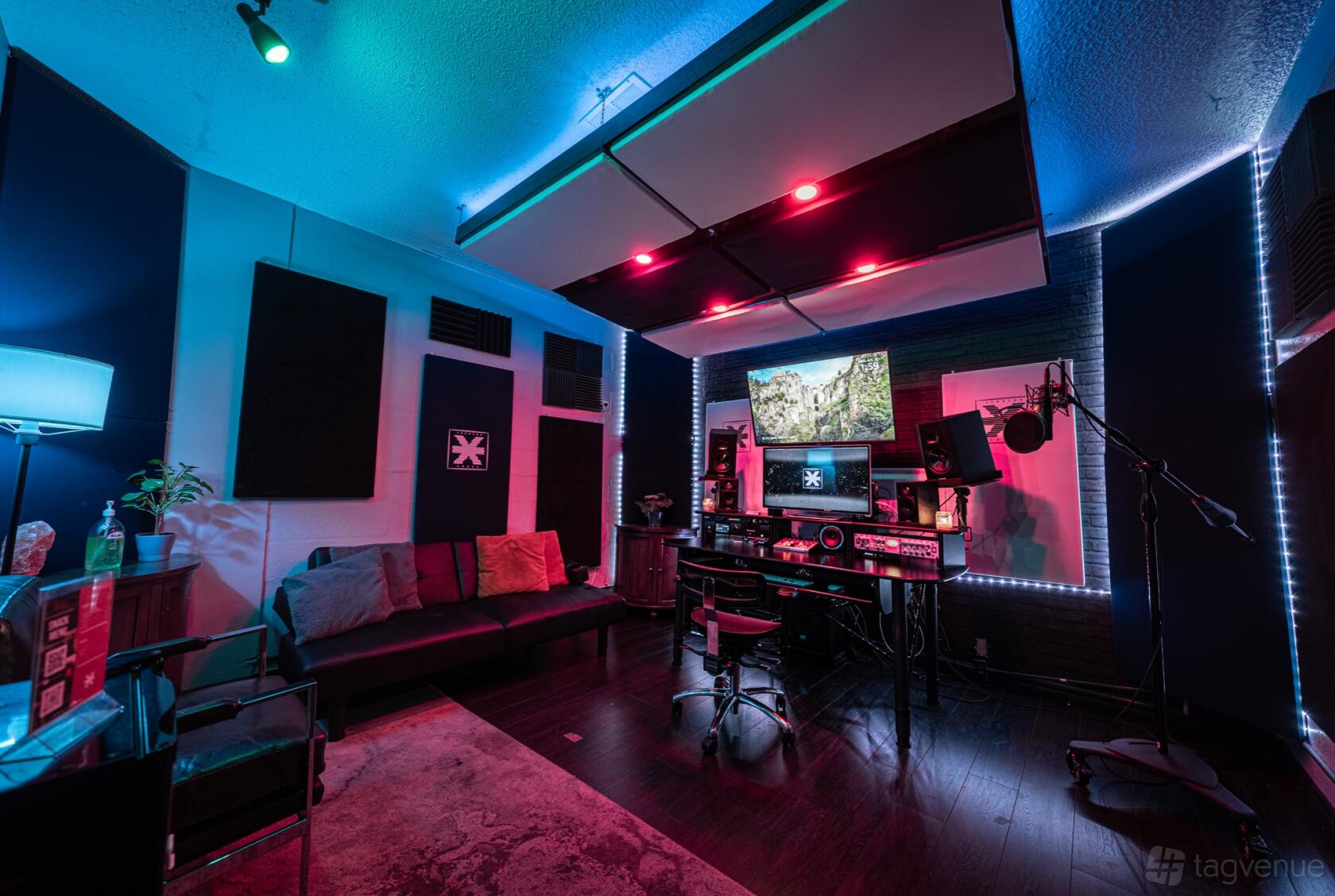 A recording studio with acoustic panels, LED lighting, a vocal booth, and mixing desk at Junxion Søund.