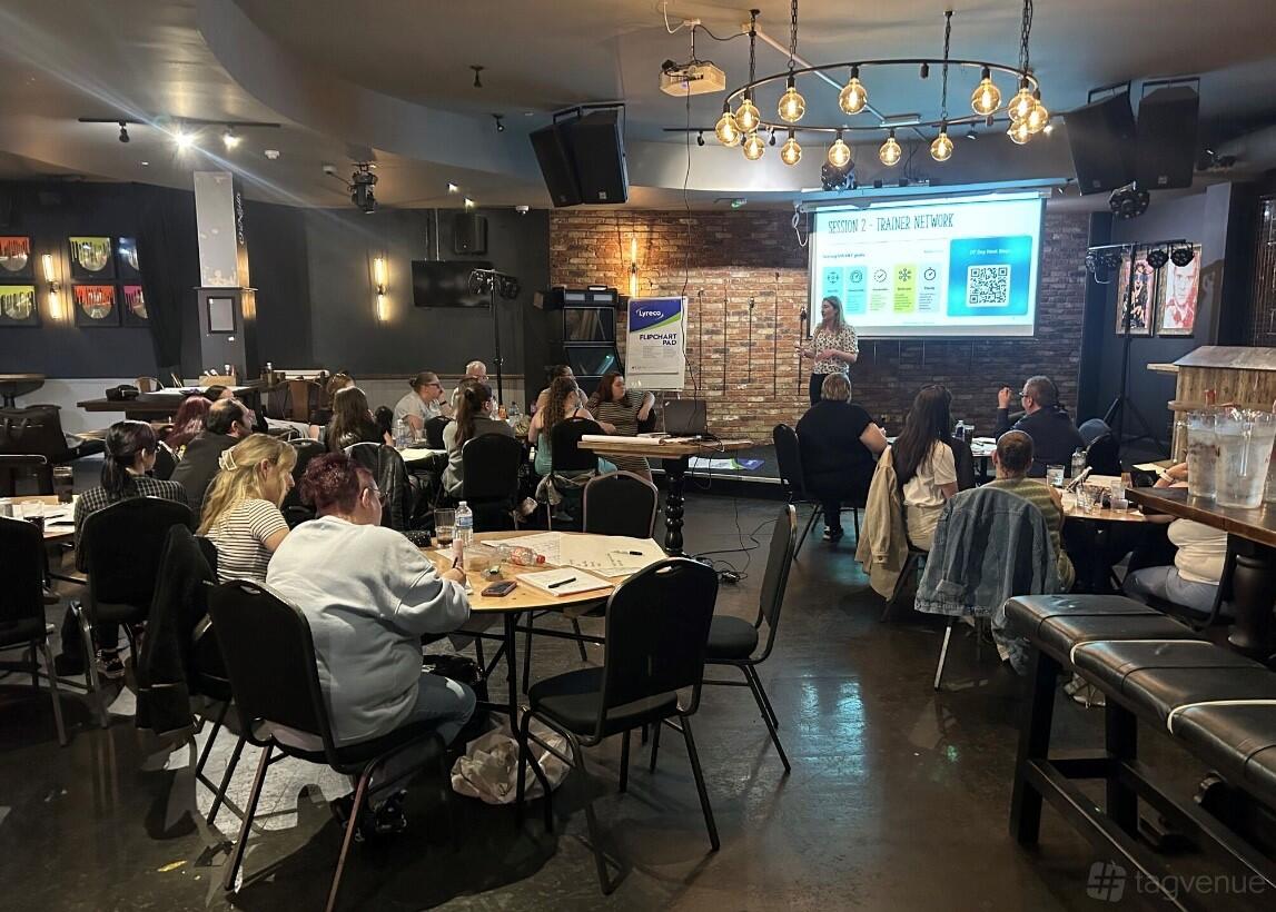 An event space in a pub with exposed brick walls, pendant lighting, and projection screen at O'Neill's Broad Street.