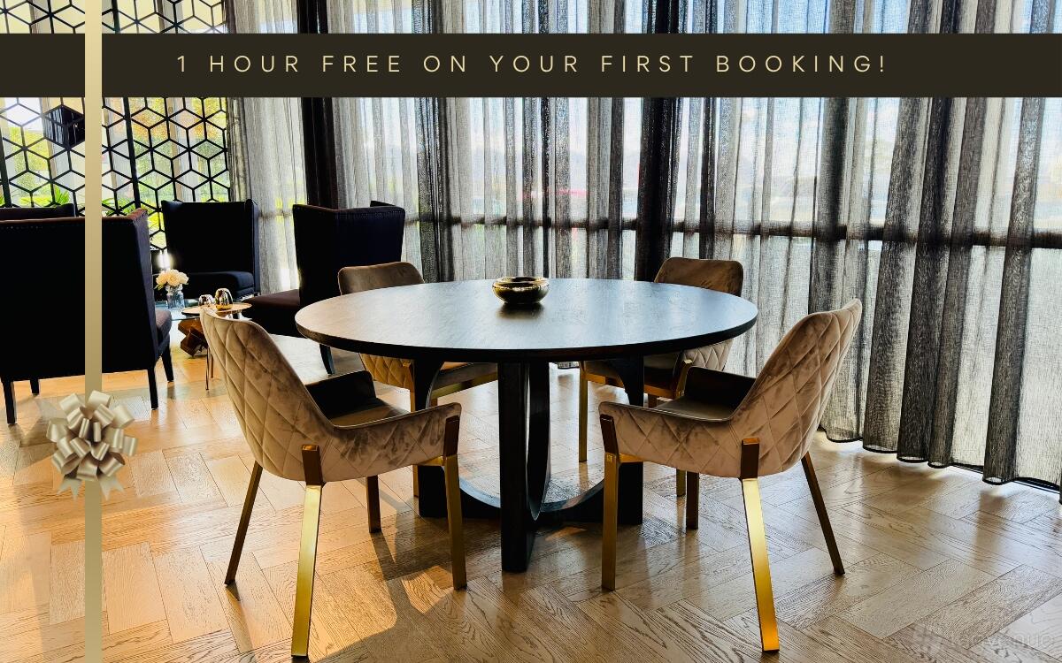 A meeting room with a round table, four velvet chairs with gold accents, and floor-to-ceiling sheer curtains at LXD Lounge Chadstone.