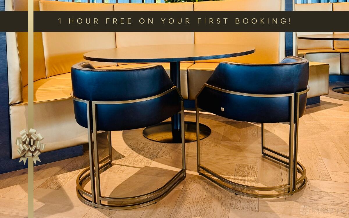 A lounge area with round wooden table, curved black chairs, and yellow upholstered booth at LXD Lounge Chadstone.