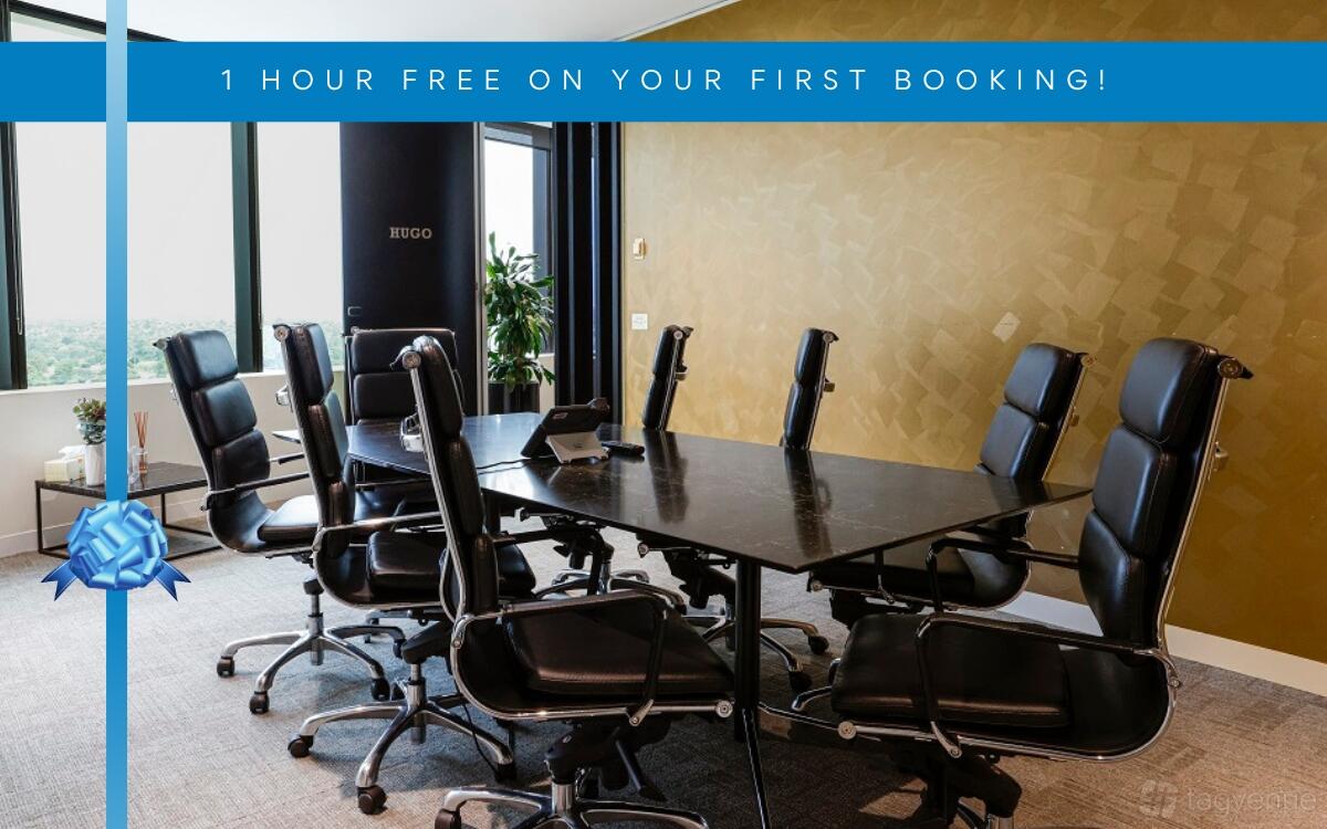 A meeting room with black leather chairs, a rectangular table, and gold accent wall at LXD Business Centre Chadstone.