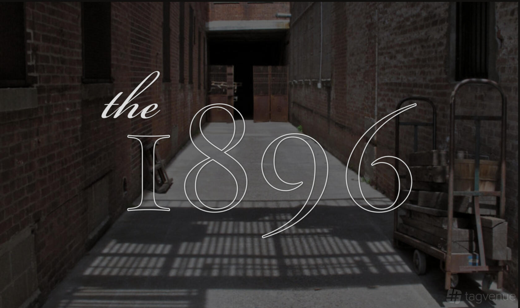A warehouse passage with exposed brick walls and industrial carts at The 1896 Studios & Stages.