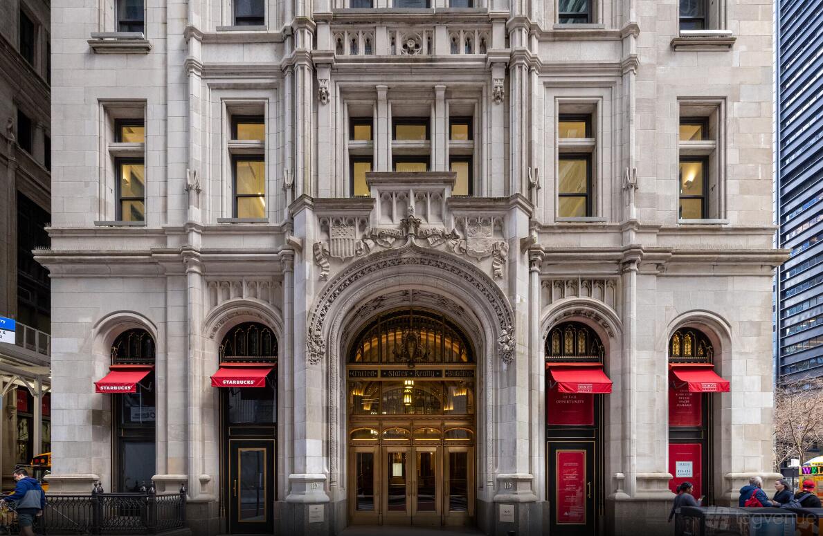 A meeting centre with a grand arched entrance, ornate stonework, and red canopies at The New York Academy of Sciences.