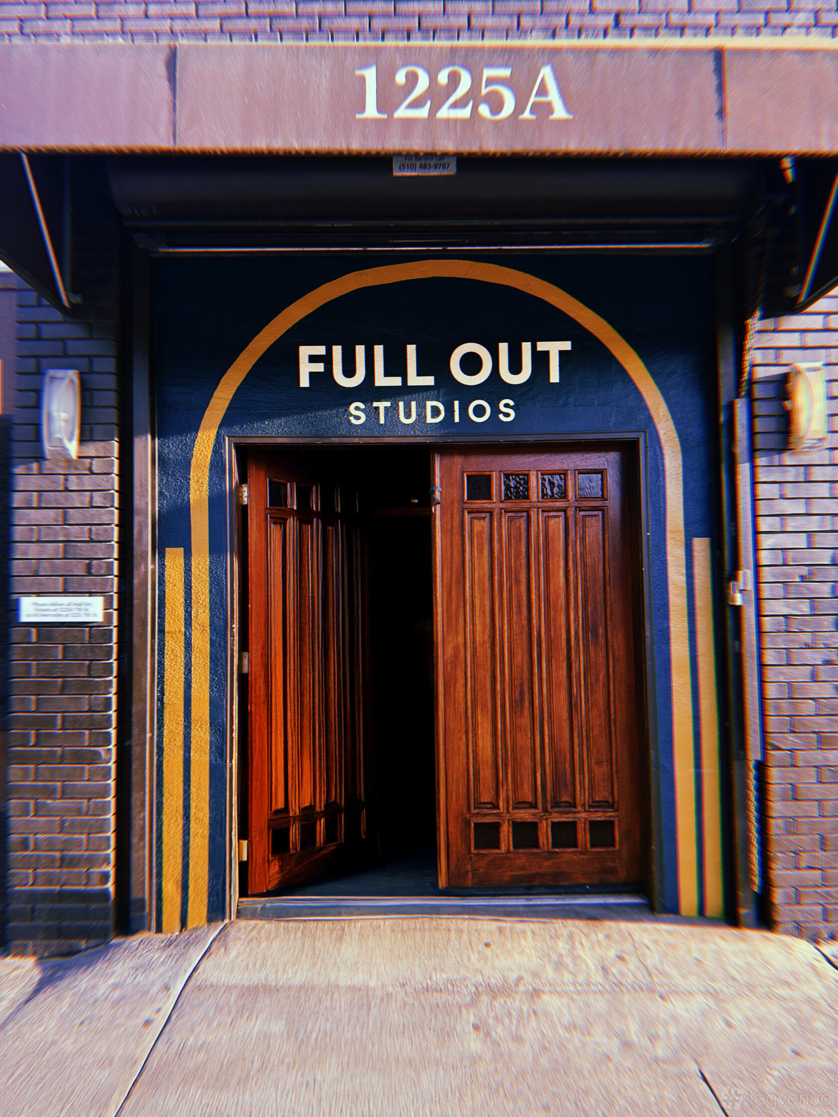 A dance studio exterior with a blue facade and tall wooden double doors at Full Out Studios.