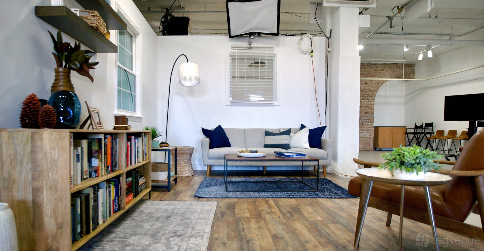 A film studio setup with a staged living room, including a sofa, bookshelves, and floor lamp at Recreation Studios.