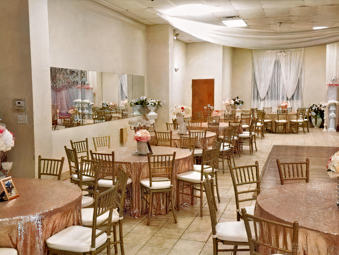 A hall with round tables covered in blush linens, gold chairs, and floral centerpieces at La Soiree Dance Hall.