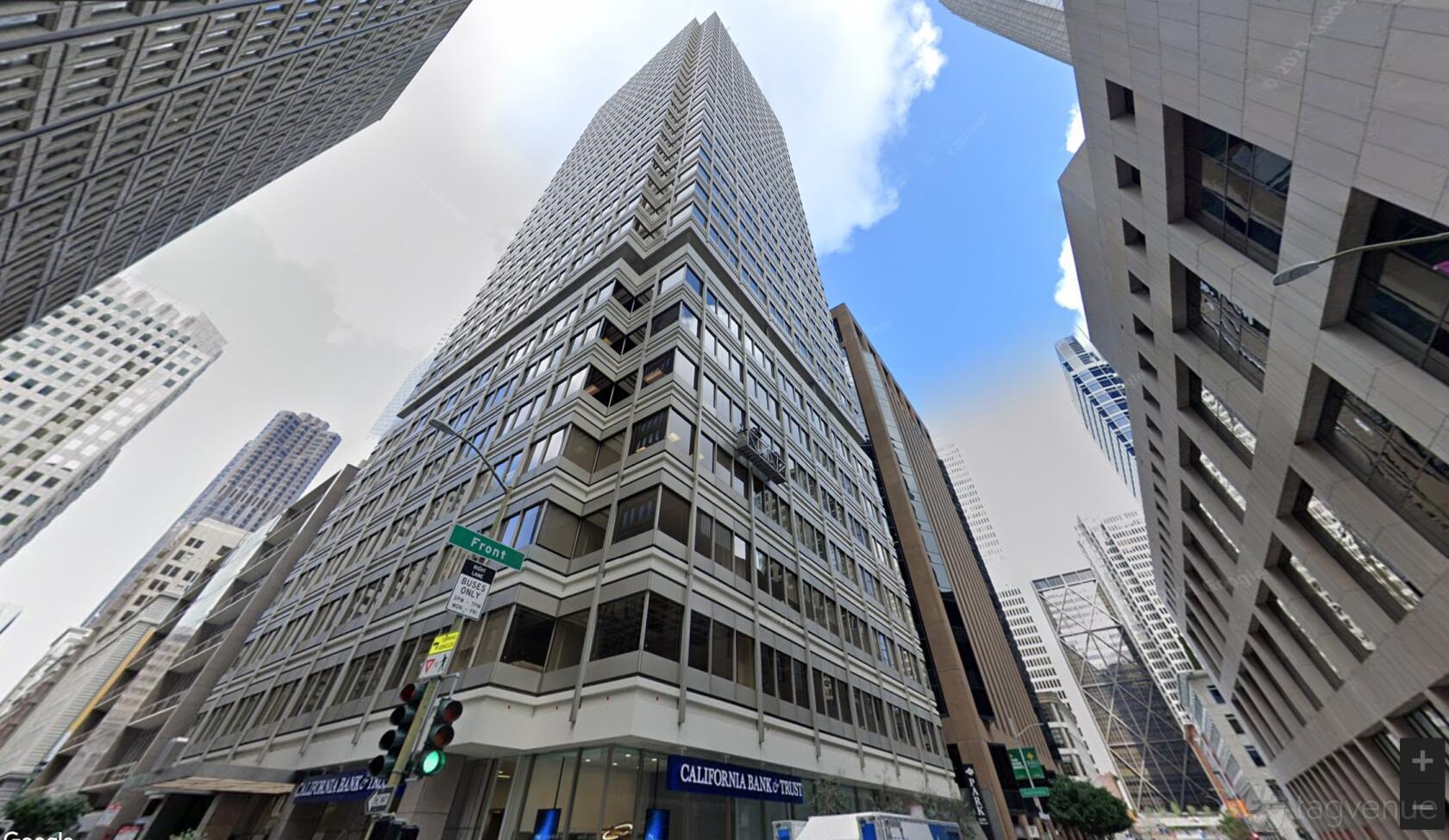 An office building with glass windows and street-level signage at Intelligent Office Financial District.