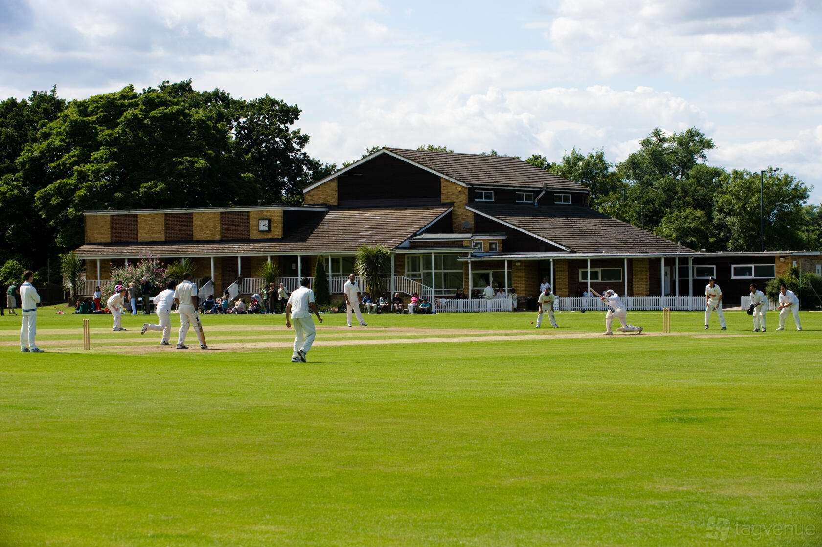 A cricket field with manicured grass and a clubhouse in the background at Trevor Bailey Sports Ground.