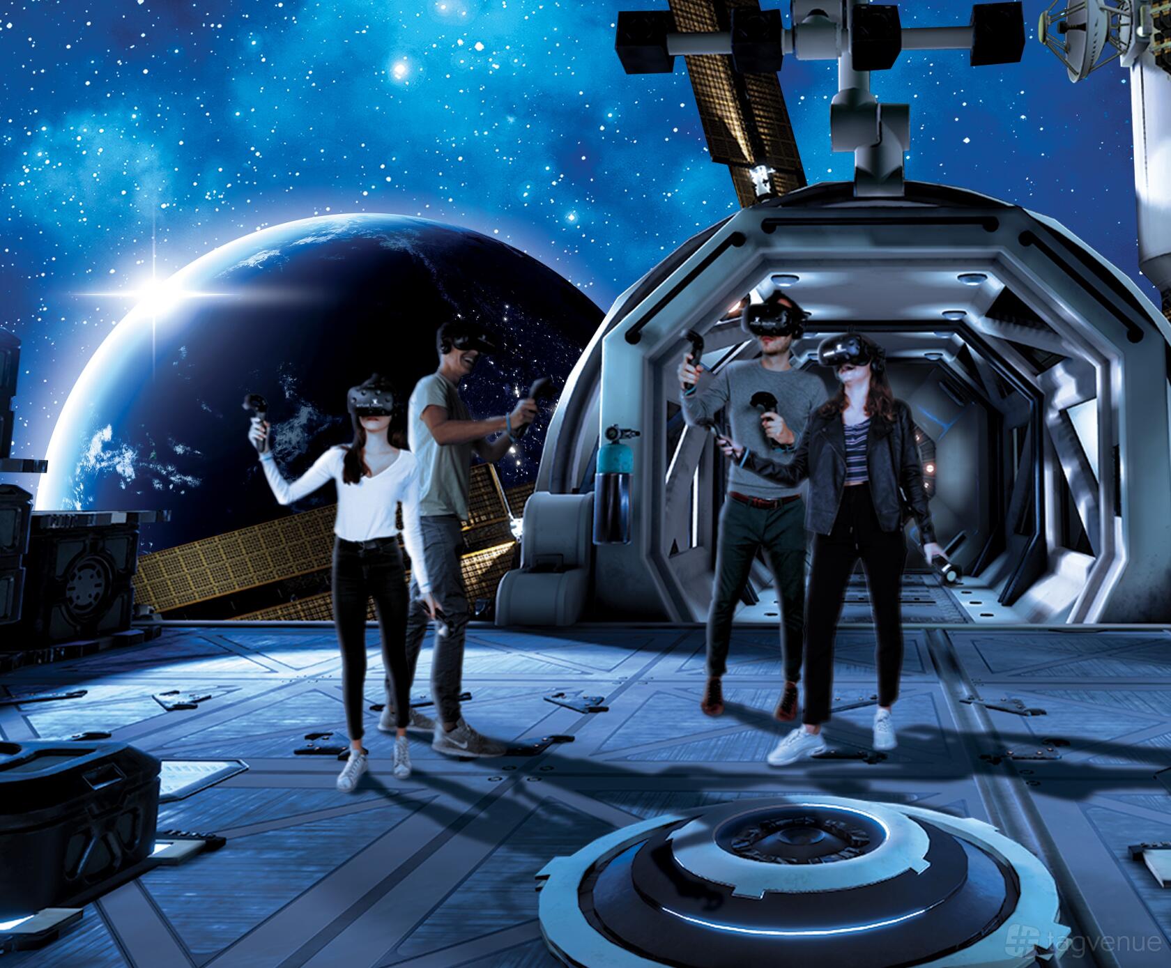 An event space with groups wearing VR headsets and controllers in a space-themed room at Virtual Room: Virtual Reality Perth.