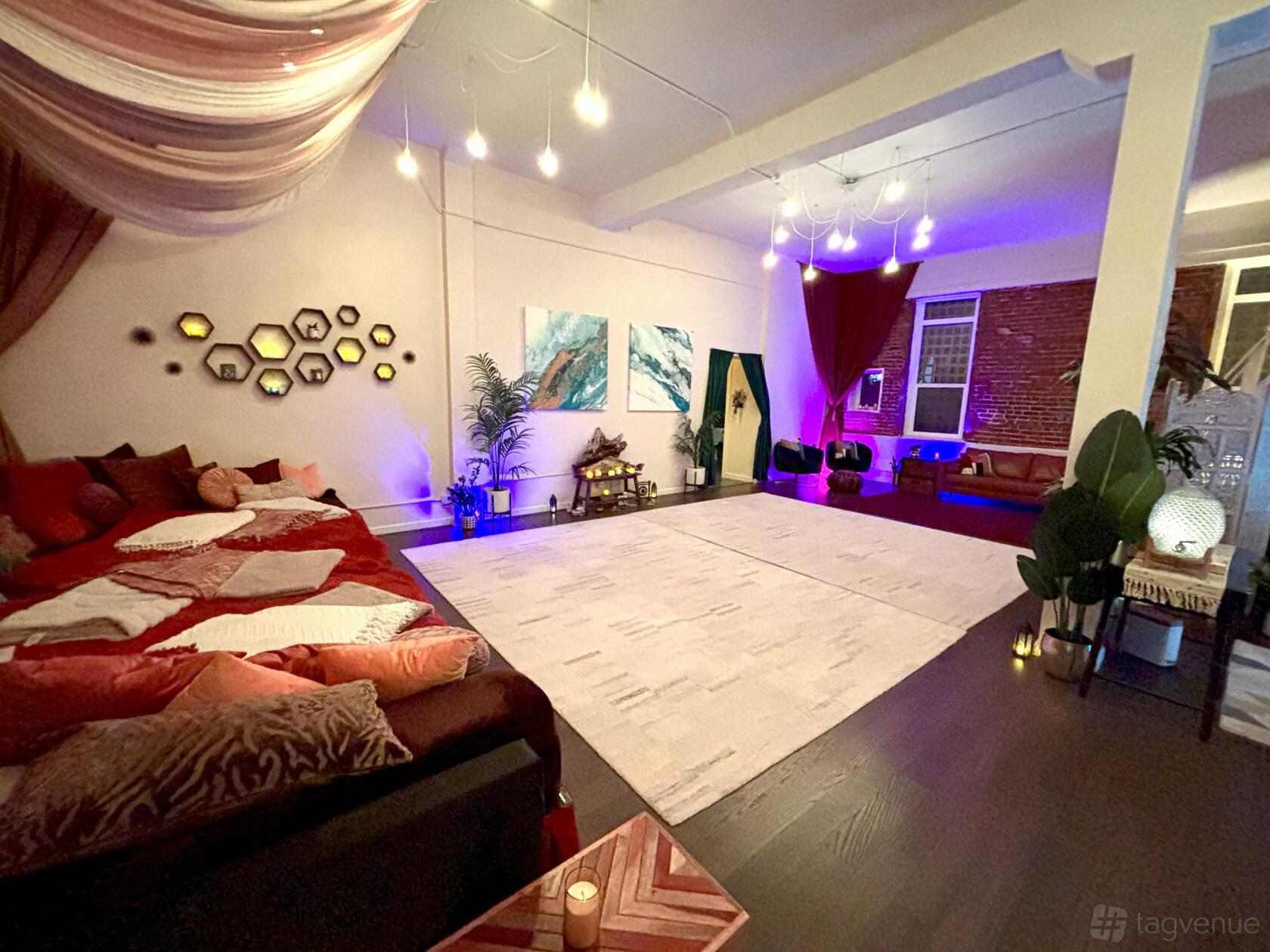 An event venue with draped ceilings, lounge seating, exposed brick, and accent lighting at HeartLab.