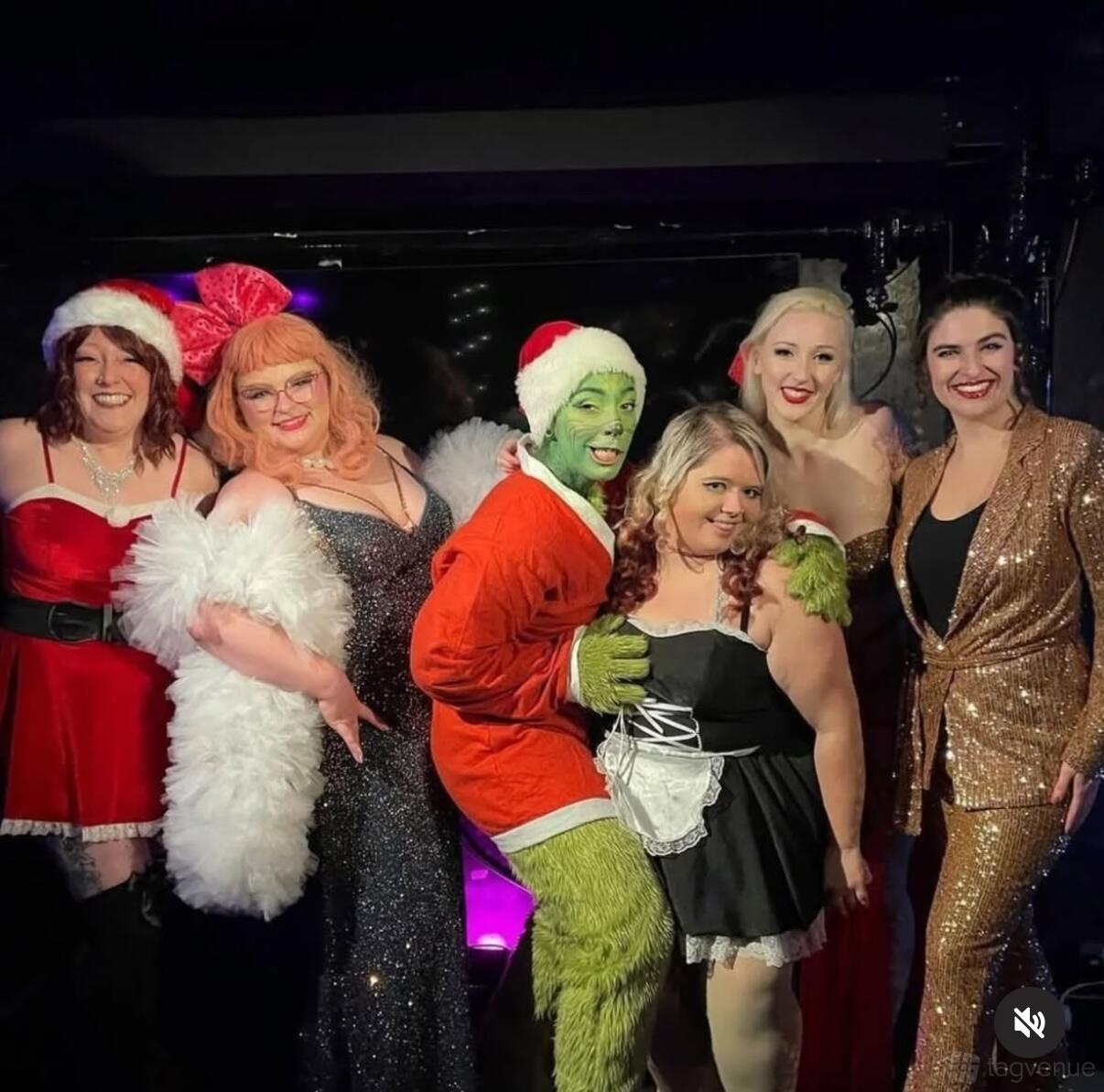 A bar with a group posing in festive costumes, including Santa hats and sequined outfits, at The Fitzgerald.