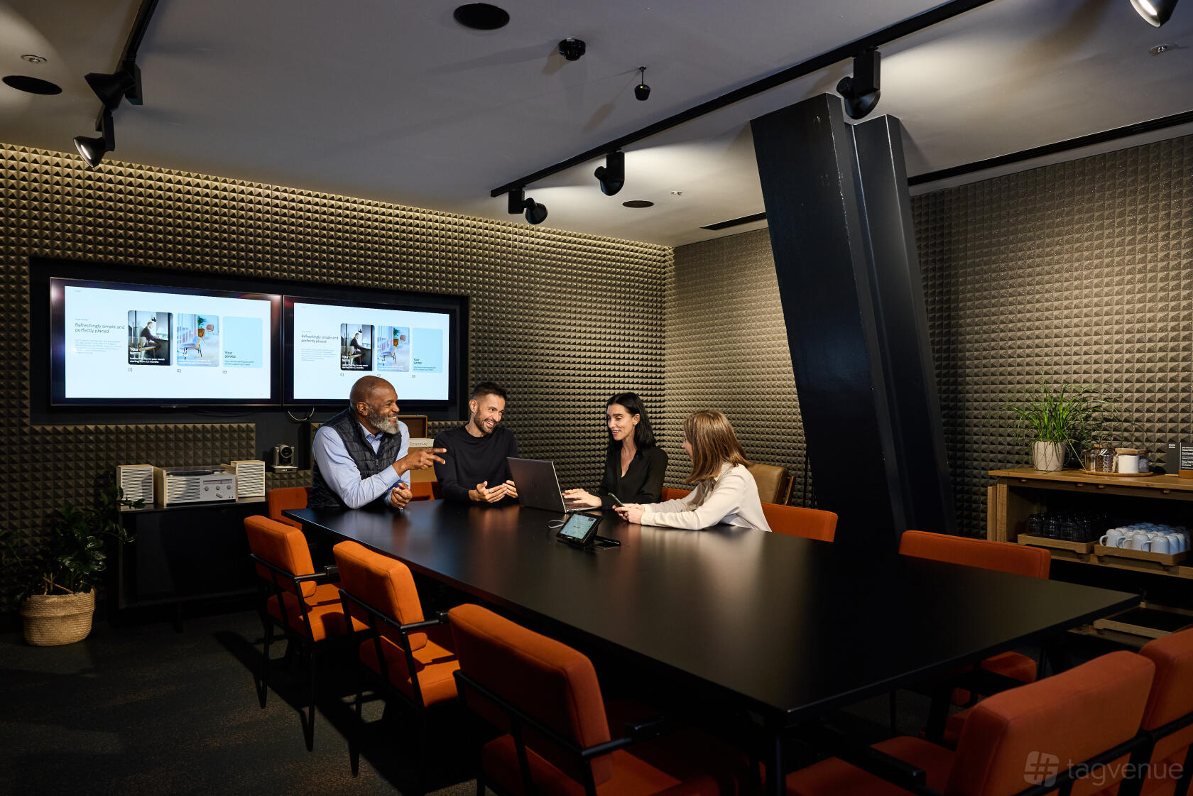 An event venue music room with soundproofed walls, two large screens, and a conference table at Storey Club Paddington.