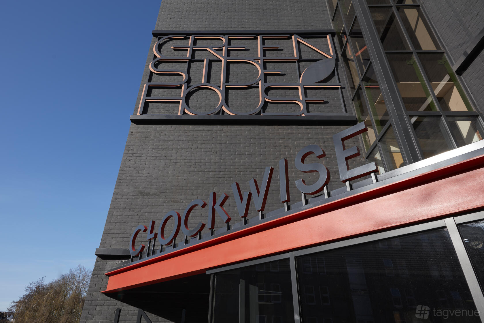 An office building exterior with large geometric windows and bold signage at Clockwise Offices Wood Green.