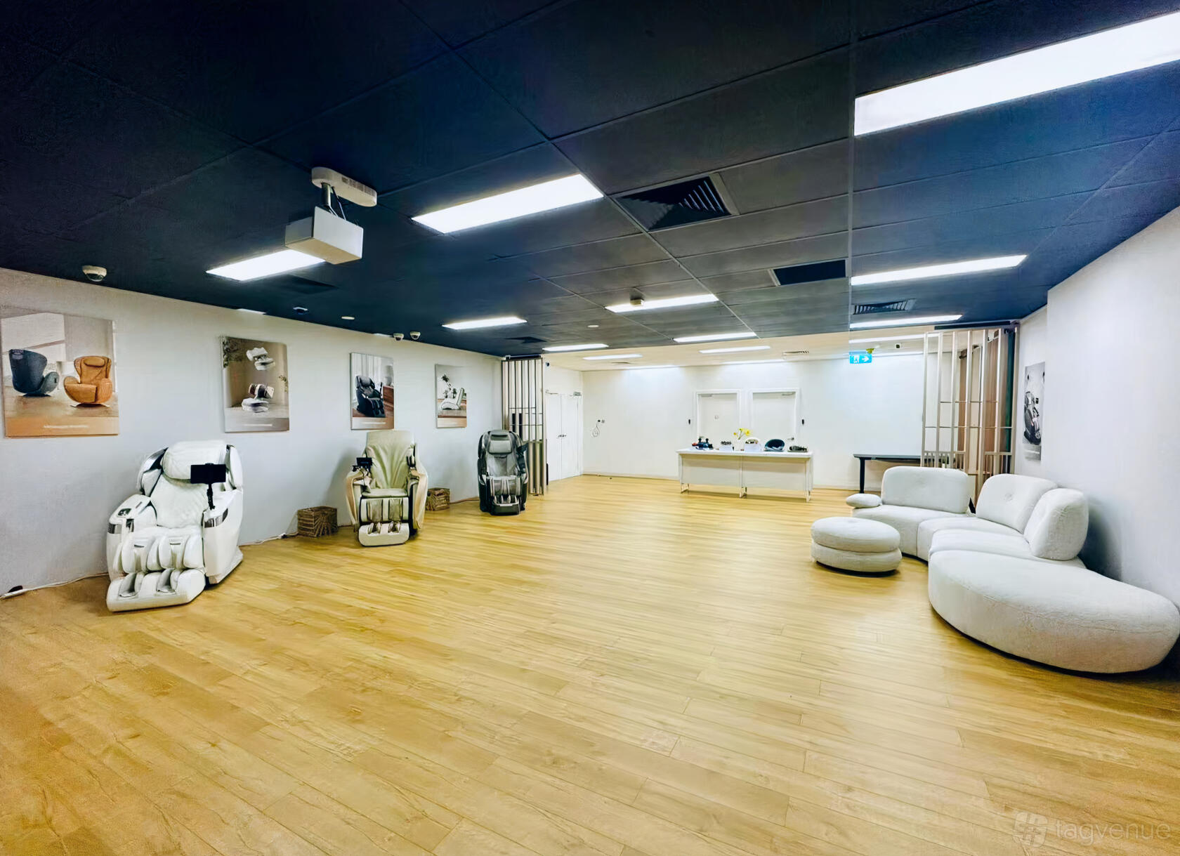 A creative space with massage chairs, soft white seating, wooden floors, and framed artwork at Irelax Sydney Flagship Store.