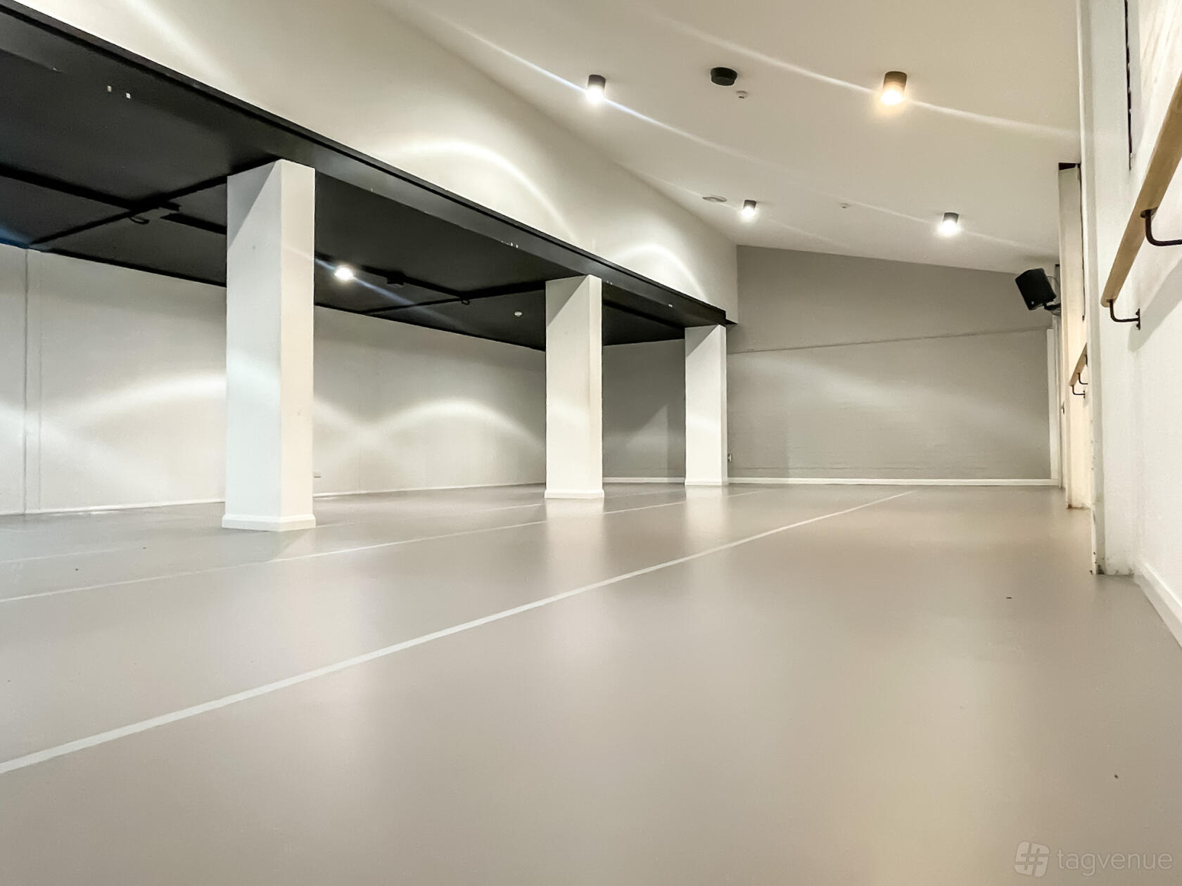 A rehearsal studio with white walls, light flooring, and ceiling spotlights at 3Danks Waterloo.
