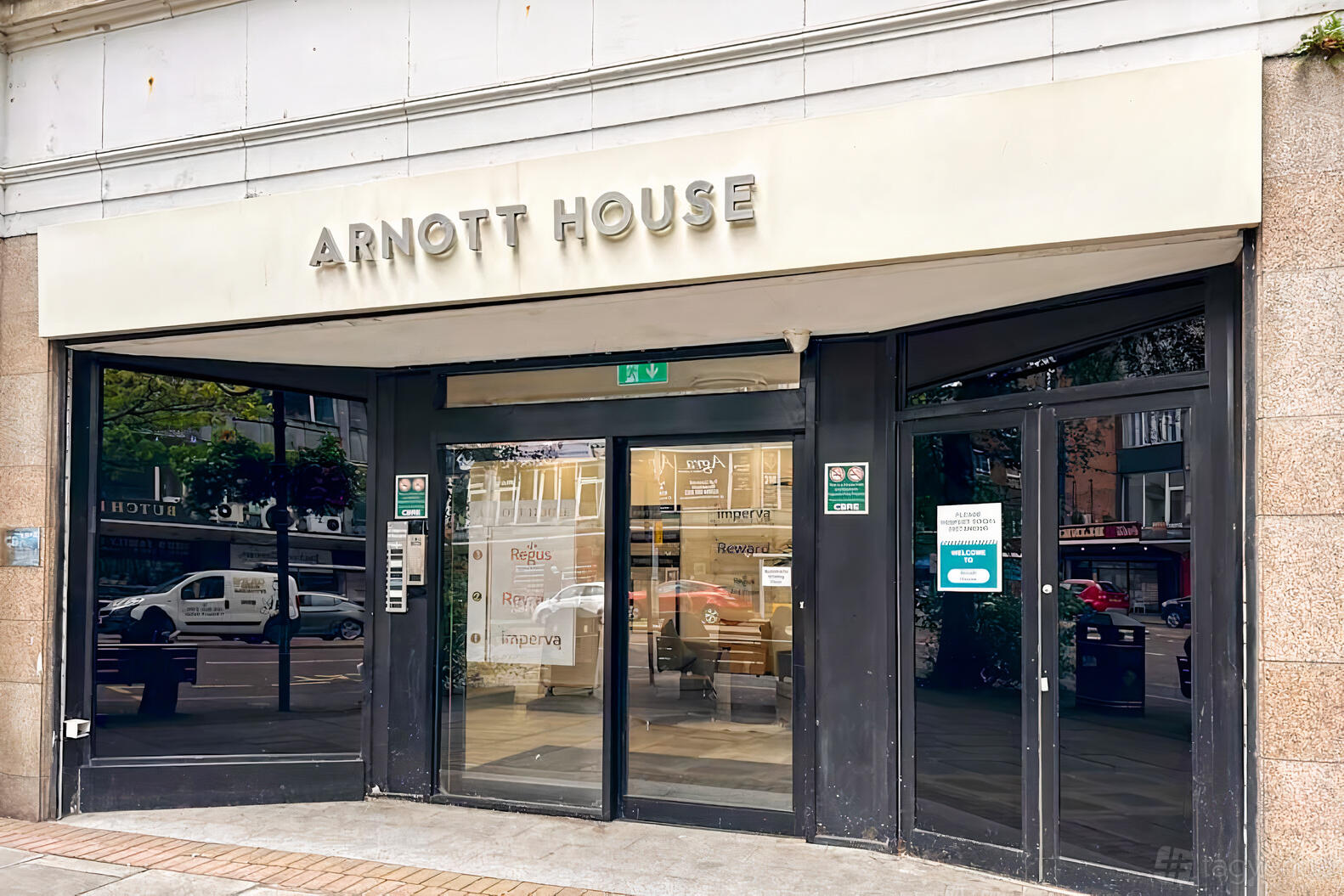 An office building entrance with large glass doors and the Arnott House sign at Regus - Belfast, Cathedral Quarter.