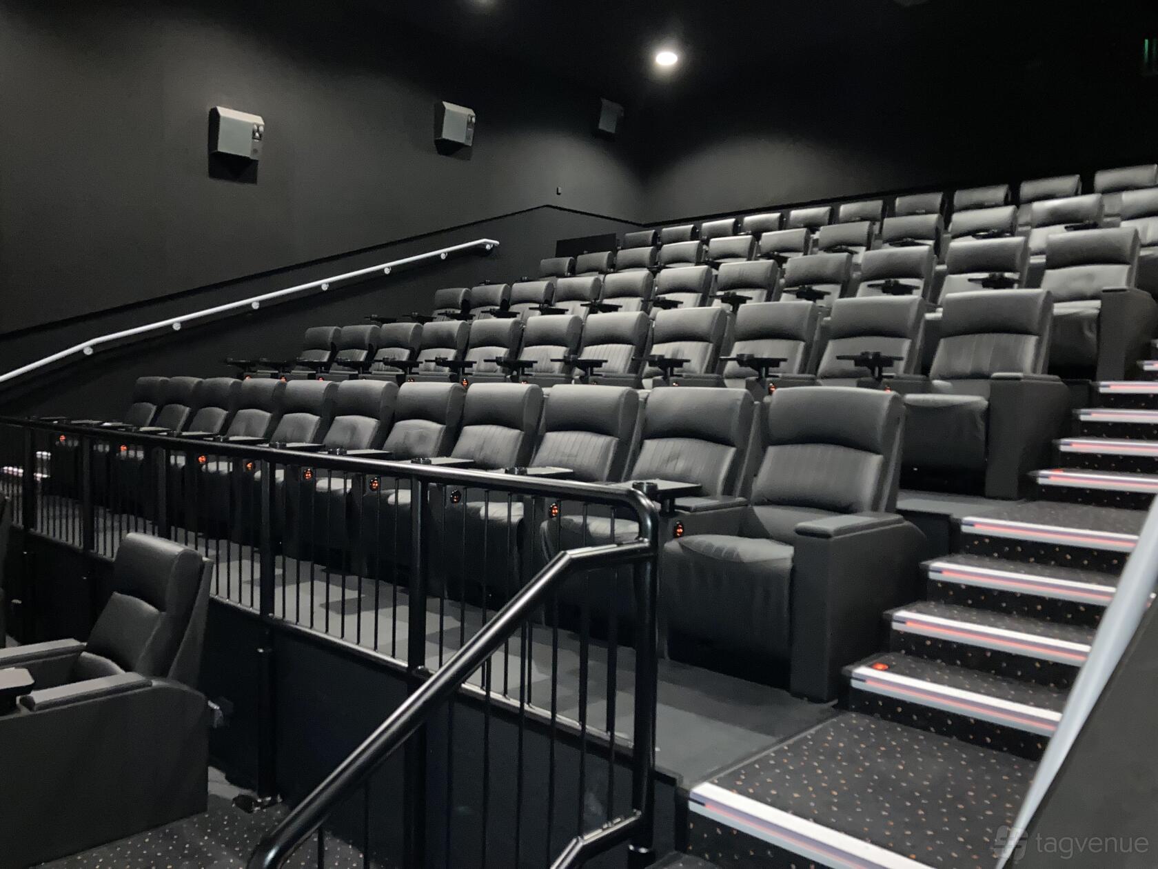 A screening room with tiered black leather seats and armrests in Vue Manchester - Printworks.