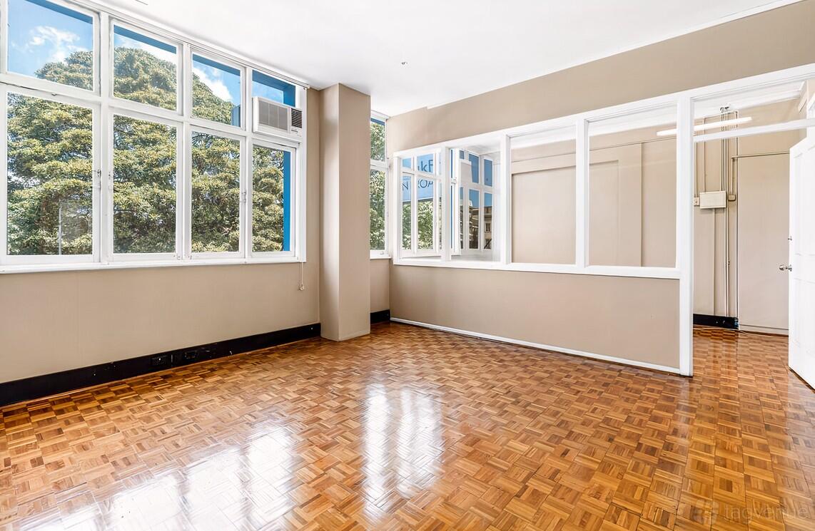 An event venue with parquet wood floors, large windows, and abundant natural light at Broadway Studio.