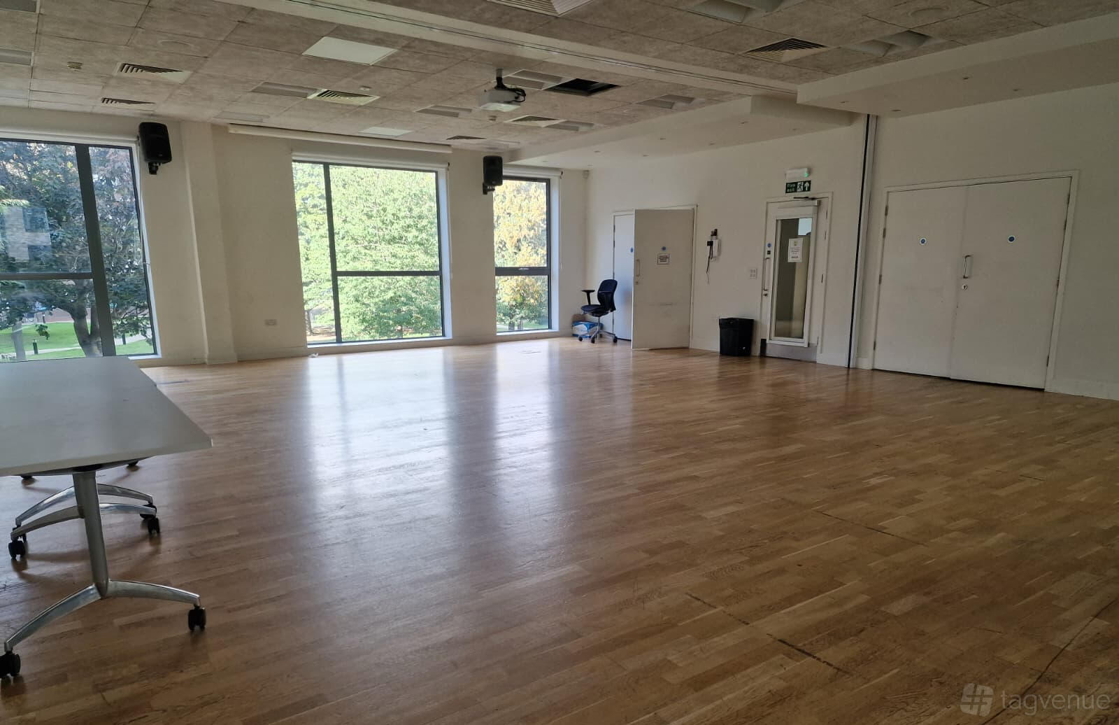 A spacious hall with large windows, natural light, and wooden flooring at St Pauls Way Community Centre.