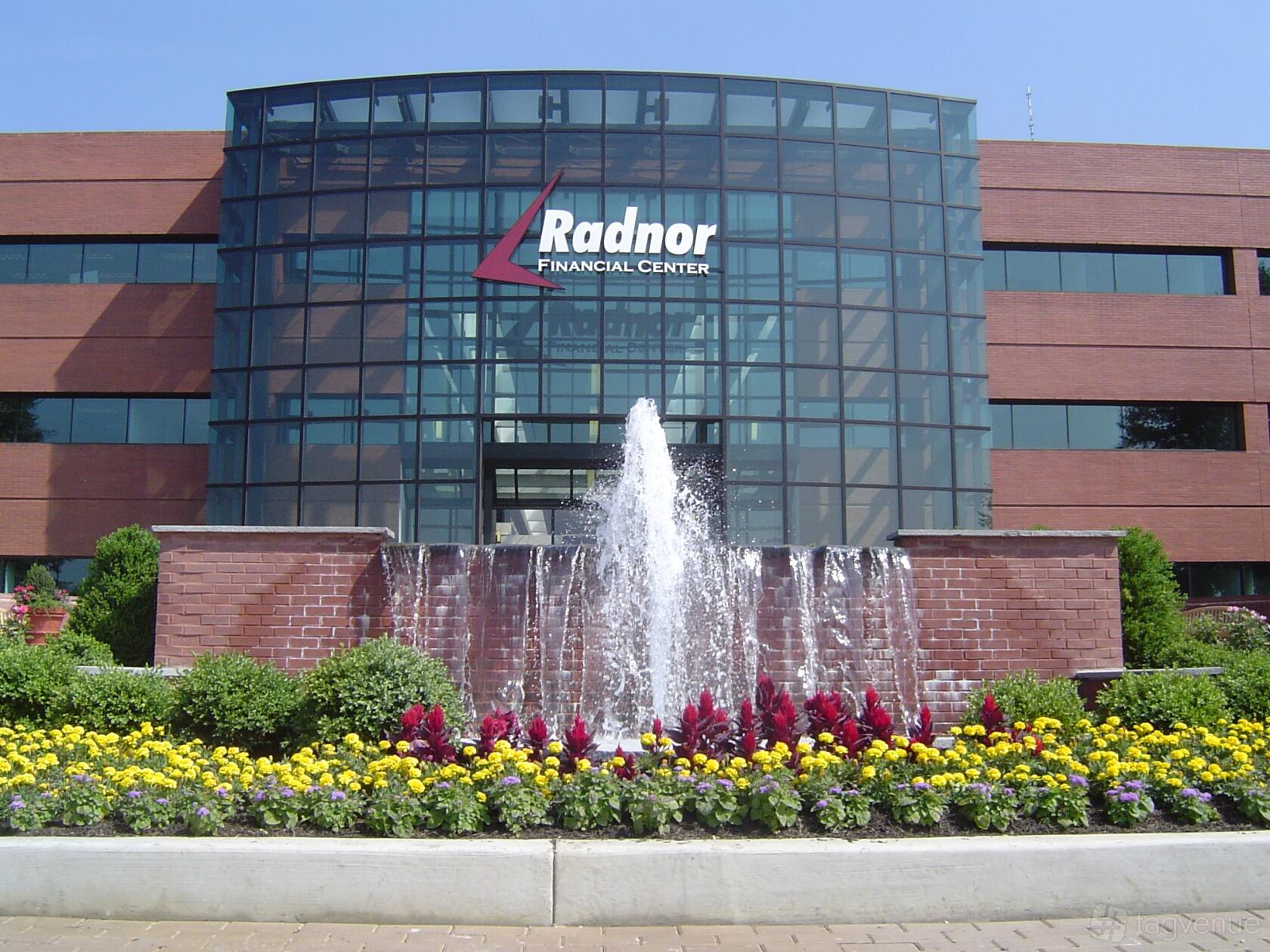 A meeting centre with a glass-fronted exterior, brick facade, and central fountain at American Executive Centers - Radnor.