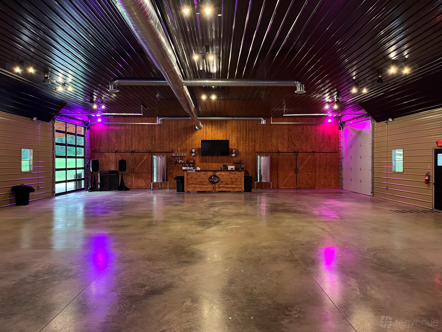 An event venue with polished concrete floors, wood-paneled walls, and exposed ductwork at Hickory Vines Winery & Venue.