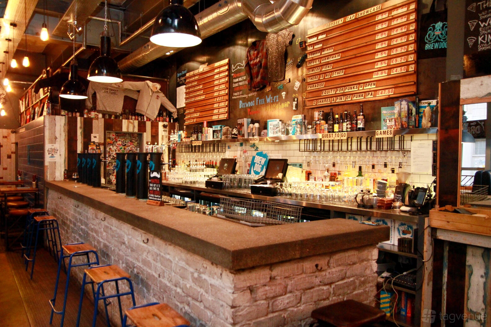 A bar event space with exposed brick bar counter, industrial lighting, and a wall of beer taps at BrewDog Edinburgh Cowgate.