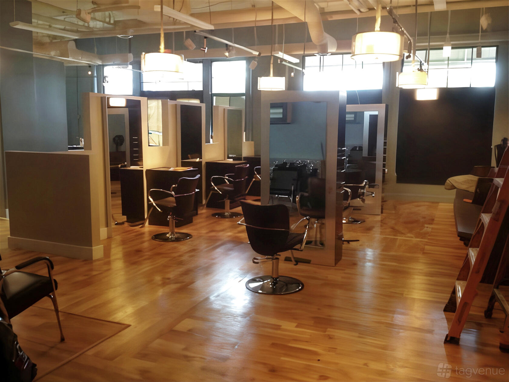 A filming location with wood floors, salon chairs, and styling stations under pendant lights at She Salon.