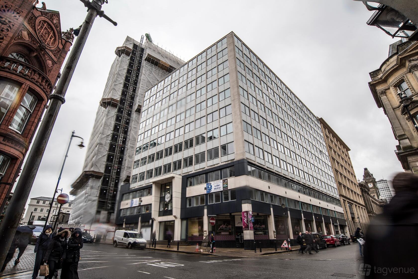 A meeting centre with a glass and concrete facade on a city street corner at Regus - Birmingham, Edmund House.